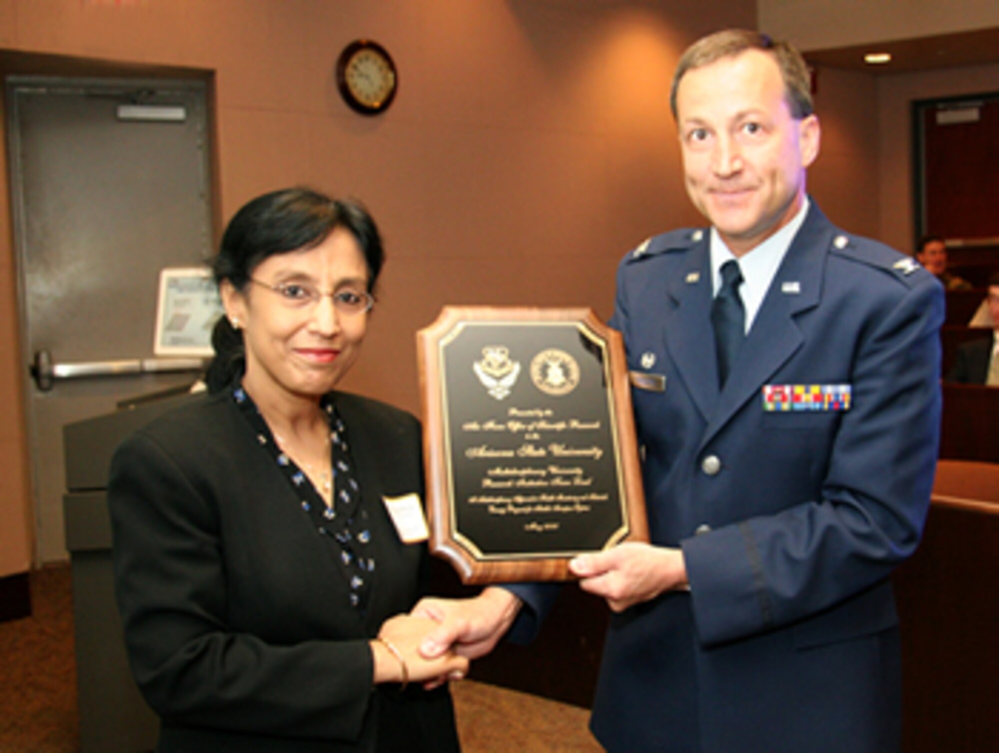 Col. Jeff Turcotte, Deputy Director at the Air Force Office of Scientific Research, presents a plaque to Prof. Aditi Chattopadhyay, Principal Investigator of the aerospace research project at the Ira A. Fulton School of Engineering at Arizona State University, supported by an $8.6 million Department of Defense Multidisciplinary University Research Initiative program grant. (Photo by Kenneth Sweat, Arizona State University)