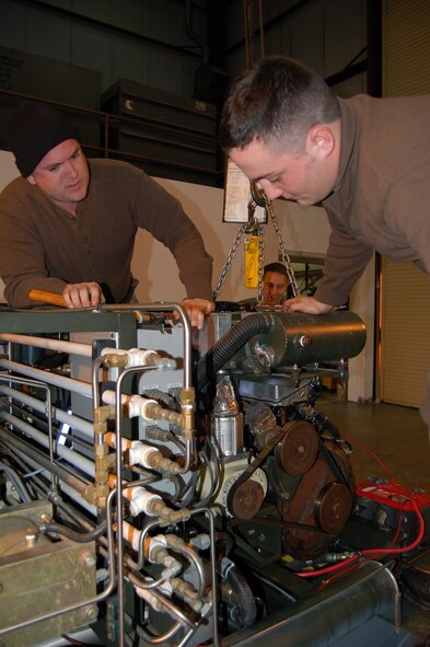 Col. Howard Seid, 433rd Airlift Wing Vice Commander, looks on as Senior Airmen Phillip Jones, left, and Brandon LaFleur, both maintainers with the 433rd Aerospace Ground Equipment Flight, work on a Self Generating Nitrogen Cart. The cart used on the C-5 Galaxy to inflate aircraft tires and landing gear struts. (U.S. Air Force Photo/Master Sergreant Collen McGee)         