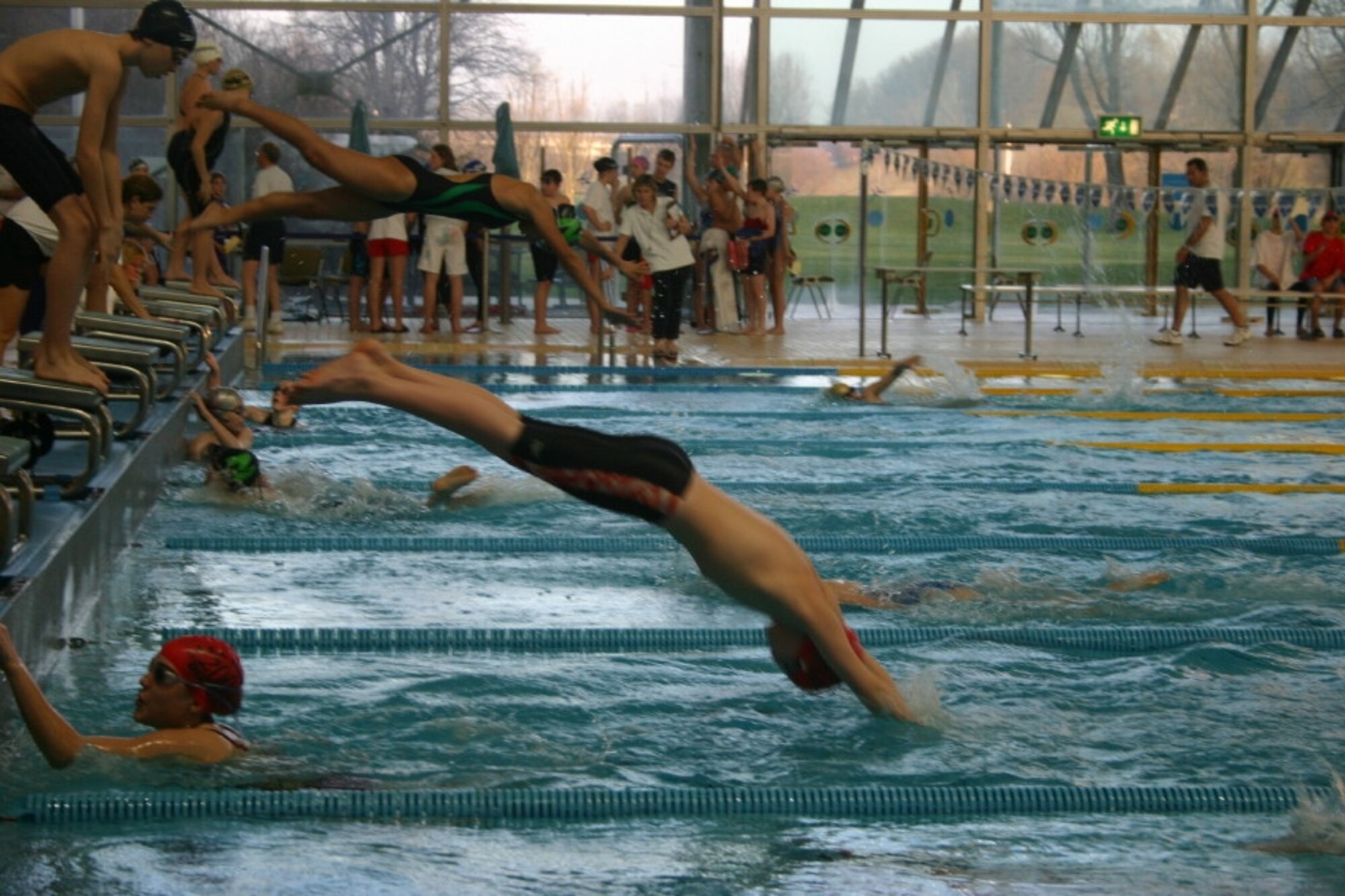 Conner Silveria, 11 years old, son of Col. Jay and Virginia Silveria, dives in for his leg of the 4x50 meter freestyle relay as teammate Alli Midthun, 12 years old, daughter of Lt. Col. Charlie and Karen Midthun, touches the wall.  The relay team placed fifth at the European Forces Swim League championships in Munich. (Photo courtesy of Virginia Silveria)