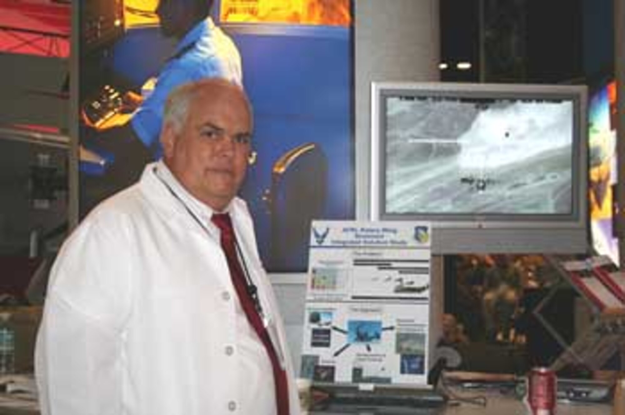 AFRL Human Effectiveness Directorate engineer, Dr William Albery, displays video and handouts on AFRL's Rotary Wing Brownout Integrated Solution Study , a program supported by four directorates identified as AFSOC's #1 operational problem.