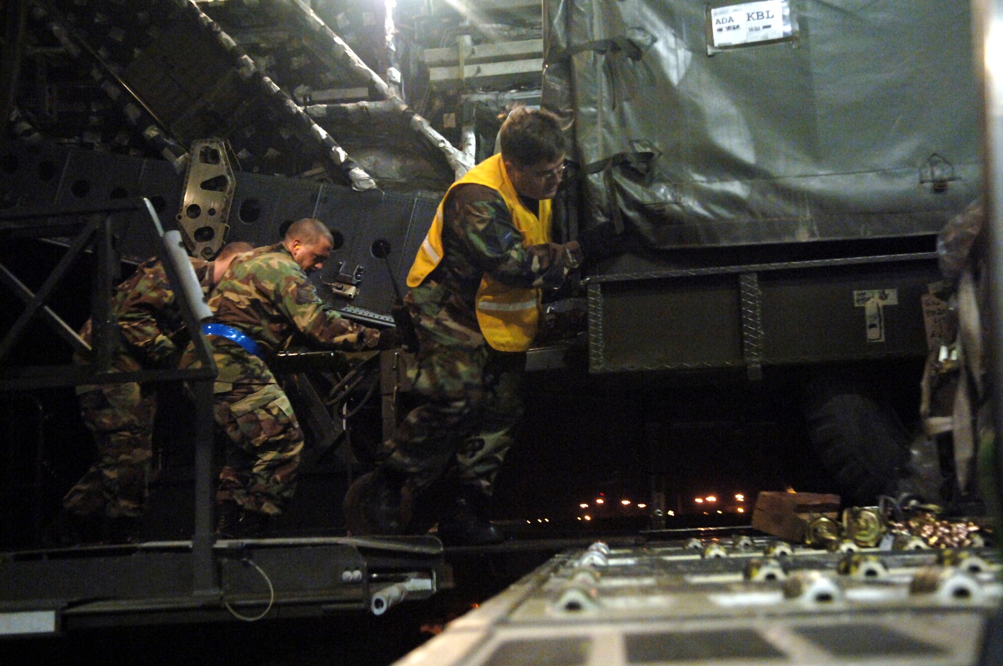 Master Sgt. James Triplett, right, Staff Sgt. Robert Izzett, center, and Airman 1st Class Thomas Hickey of the 728th Air Mobility Squadron load a trailer onto a C-17 Globalmaster III late Tuesday night at Incirlik Air Base, Turkey. The pallets and trailers loaded for transport included uniforms and equipment for the Afghan army. (U.S. Air Force photo by Airman 1st Class Nathan W. Lipscomb)