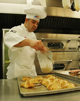 Senior Airman Angelo Apodaca, 302nd Services Flight services technician, applies icing to turnovers at the Aragon Dining Hall. (U.S. Air Force photo by Tech. Sgt. Tim Taylor)