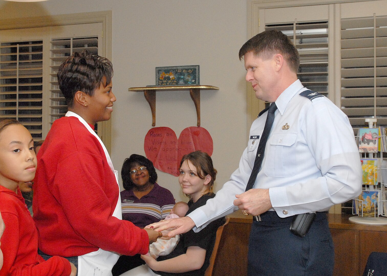 Col. Eric Wilbur, vice commander of the 37th Training Wing at Lackland Air Force Base, Texas, thanks Tech. Sgt. Lakesha S. Washington, 345th Training Squadron, and her daughter, Myesha, for volunteering at the Lackland Fisher House. The African-American Heritage Committee prepared dinner for some 30 patients, family members and staff Feb. 15 as part of a monthlong activities aimed at recognizing African-Americans and their contributions to the country.(USAF photo by Robbin Cresswell) 