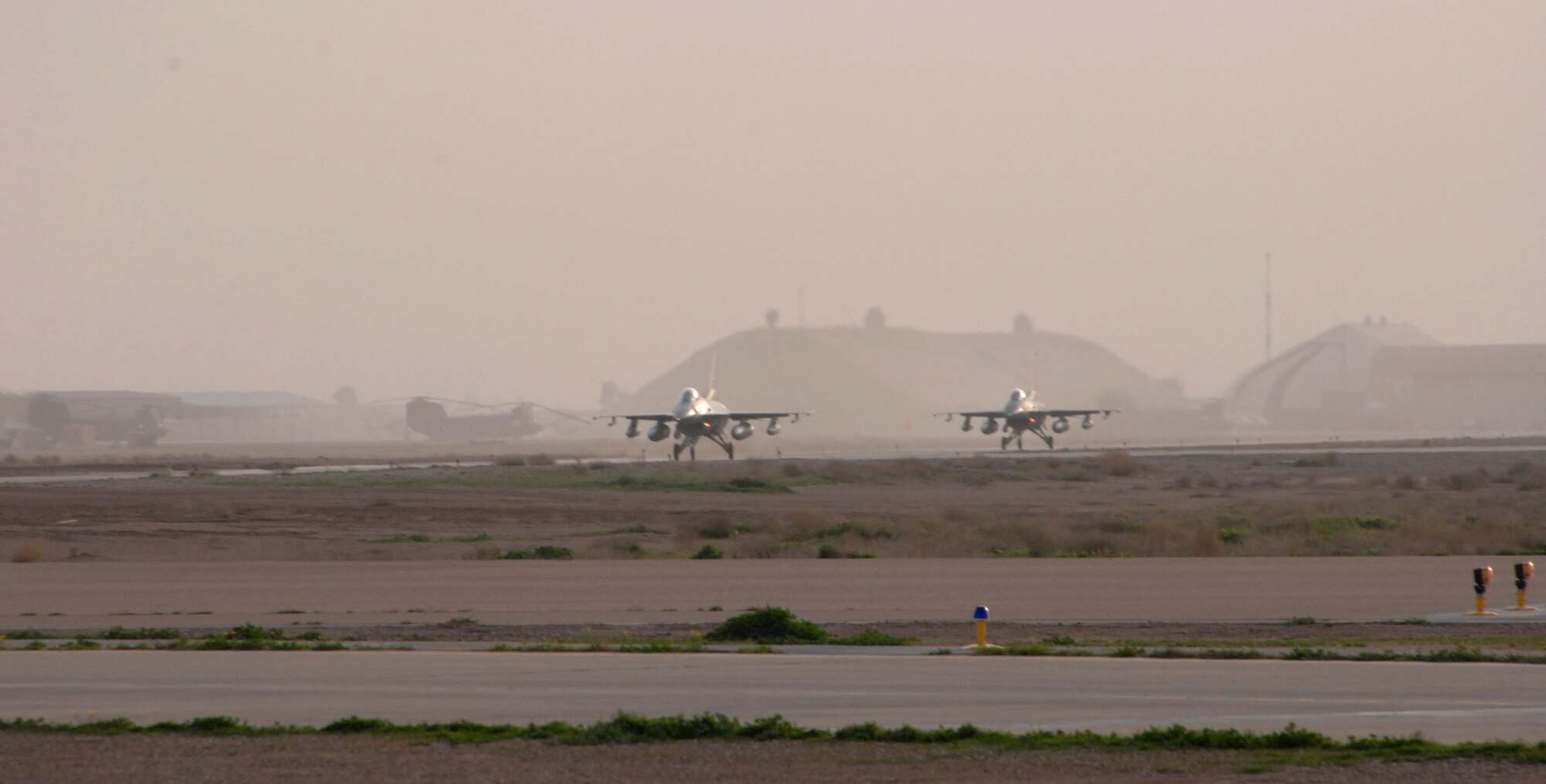 Two F-16 Fighting Falcons assigned to the 332nd Expeditionary Fighter Squadron arrive Feb. 26 at Balad Air Base, Iraq. The F-16s are deployed from the Minnesota Air National Guard's 148th Fighter Wing along with roughly 400 guardsmen in support of Operation Iraqi Freedom. (U.S. Air Force photo/Tech. Sgt. Julie M. Tomaska)
