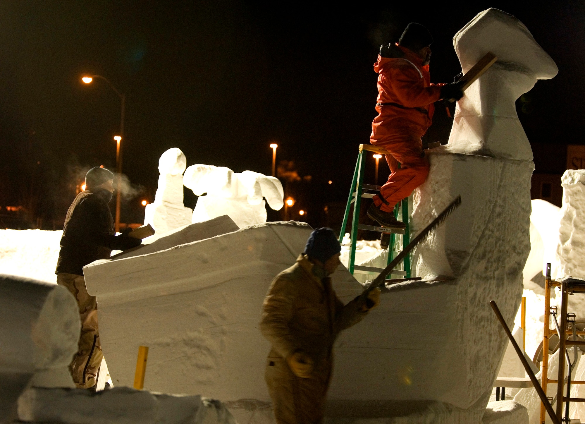 Staff Sgt. Edward Tompkins, Eric Zimmerman and Mitchell Manzo, comprising the Elmendorf Air Force Base snow sculpting team, chop, saw and smooth away snow to create a pirate ship Feb. 23 during the Anchorage, Alaska, Fur Rendezvous snow sculpture competition.  The team was vying for a chance to be invited to the 2008 National Snow Sculpting Championship in Lake Geneva, Wis. (U.S. Air Force photo/Senior Airman Garrett Hothan)