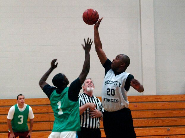 Mike Evans, 437th Security Forces Squadron, wins the jump ball at the start of the game over Sean Veney, 437th Security Forces Squadron. SFS trounced AMXS 65-34. (U.S. Air Force photo/Airman 1st Class Nicholas Pilch)