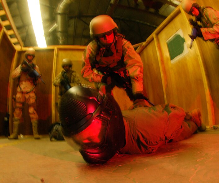 Airmen of the 90th Ground Training Squadron secure a "hostile" member as the group simulate a hostage situation Feb. 8 at Camp Guernsey, Wyo. Once the enemy has been suppressed the hostage is quickly escorted away from the site. Camp Guernsey is an Army Reserve training ground used by the 90th Space Wing for convoy security, sniper training and close quarters combat training including other specialty training. (U.S. Air Force photo/Senior Airman Javier Cruz Jr.) 