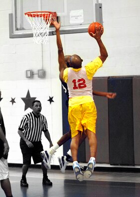 EGLIN AIR FORCE BASE, Fla. -- Robert Taylor (12), 96th Medical Group, tries to shoot a layup over Brandon Burton, Air Armament Center, during the Over 30 Basketball Champinoships Feb. 21. The Med Group forced a second game in the double-elimination tournament held at the main fitness center with a 43-37 win. The AAC won the tournament in a decisive final game 61-53 to claim the champinoship. (U.S. Air Force photo/Will Vandermate)