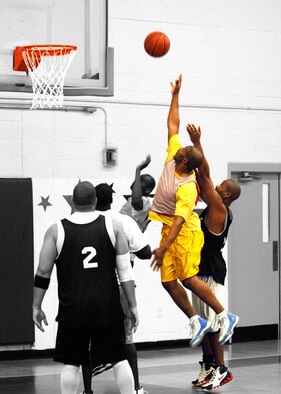 EGLIN AIR FORCE BASE, Fla. -- Robert Taylor (12), 96th Medical Group, reaches up to steal a rebound during the Over 30 Basketball Champinoships Feb. 21. The Med Group forced a second game in the double-elimination tournament held at the main fitness center with a 43-37 win. The AAC won the tournament in a decisive final game 61-53 to claim the champinoship. (U.S. Air Force photo/Will Vandermate)
