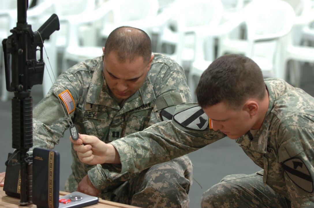 Chaplain (Capt.) Eric Bey, 1-12 Combined Arms Battalion, 3rd Brigade Combat Team, 1st Calvary Division, and another Soldier honor Staff Sgt. Daniel Morris during his memorial at a Forward Operating Base in Iraq, Nov. 27, 2006. (Photos by Army Spc. Ryan Stroud, 3rd BCT, 1st Cav. Div. PAO)