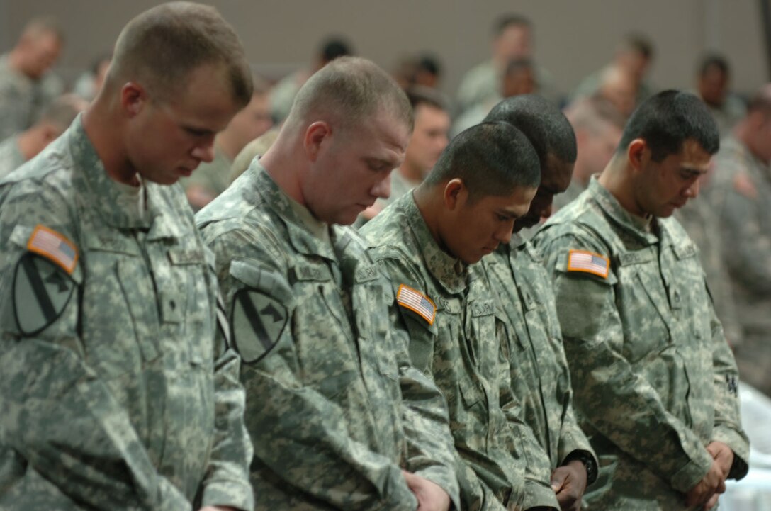 Soldiers bow their heads in honor of their fallen comrade, Army Staff Sgt. Daniel Morris, during his memorial at a Forward Operating Base in Iraq, Nov. 27, 2006.