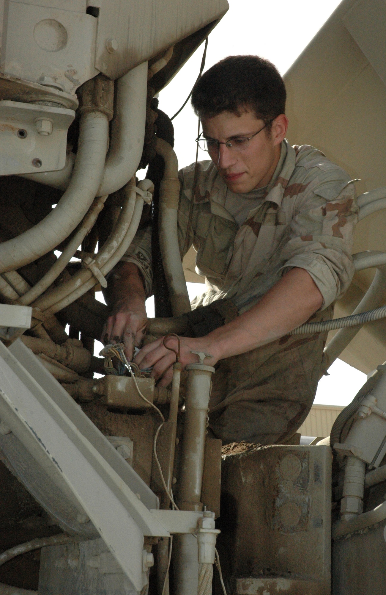 Senior Airman Nic Skirpan inspects engine components and hydraulic fittings on a 20-ton rock dump Feb. 19 in Southwest Asia. RED HORSE vehicles from all over the area of responsibility are sent back to the 379th Air Expeditionary Wing here for maintenance and repair work. Airman Skirpan is a 1st Expeditionary Red Horse Group vehicle maintenance journeyman. (U.S. Air Force photo/Senior Airman Erik Hofmeyer)
