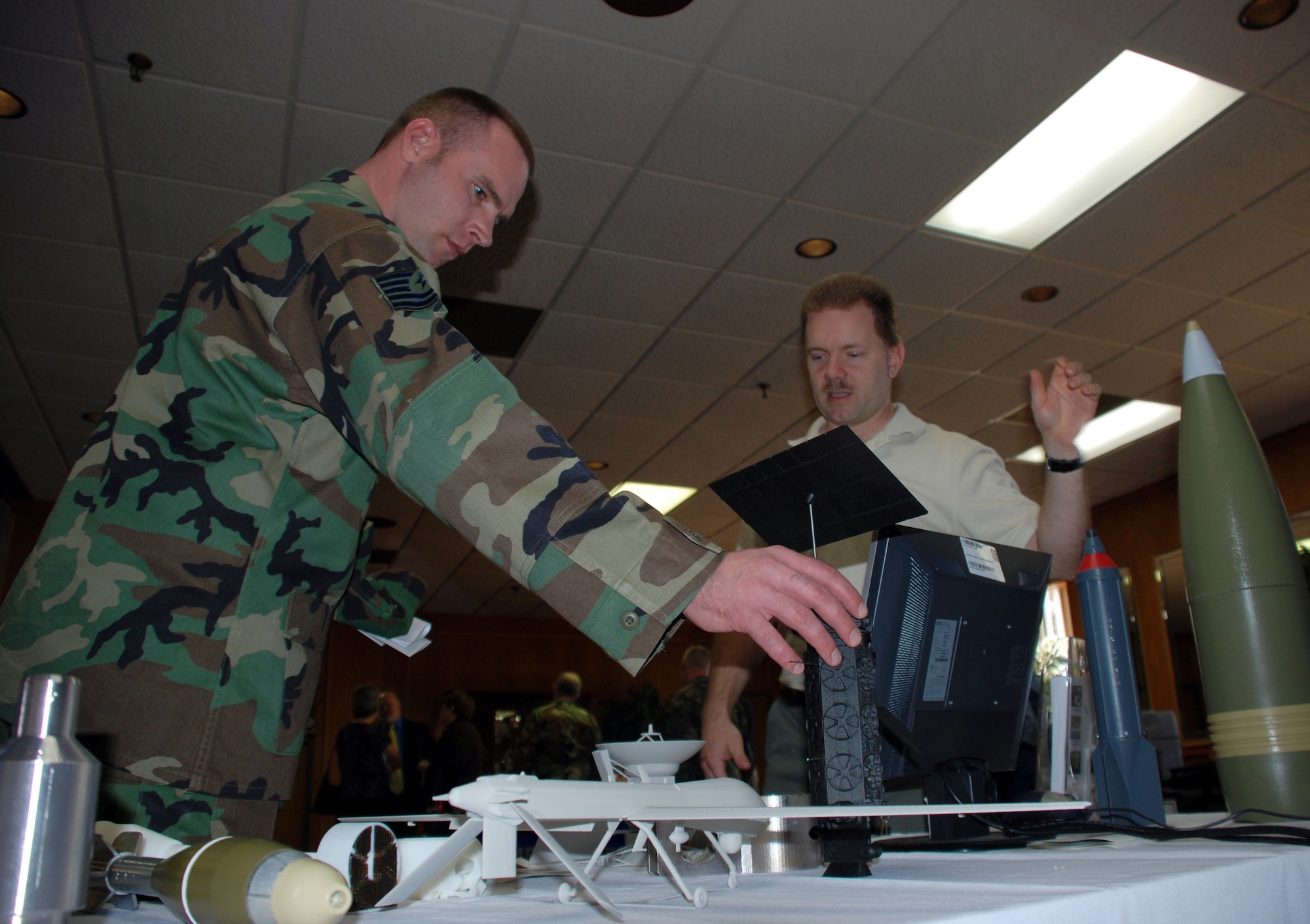David Hendricks, a production controller with the 982nd Maitenance Support Squadron's training support flight, shows some of the products created by the flights fused deposition modeler to Tech Sgt. Stephen Stults, a operations managerwith the 372nd Training Squdron, at the 5th Annual Sheppard Tech Expo Feb. 27. (U.S. Air Force photo/Airman 1st Class Jacob Corbin)
