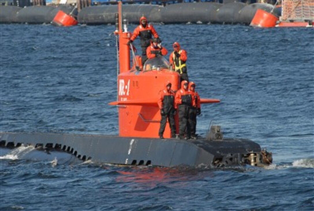 U.S. Navy sailors aboard nuclear research submarine NR-1 get under way from Naval Submarine Base New London in Groton, Conn., Feb. 12, 2007, making way down the Thames River.