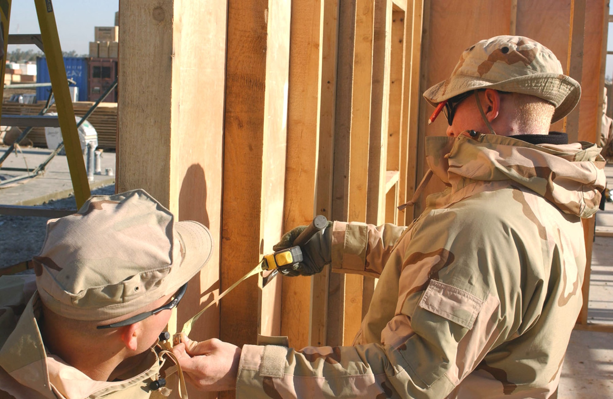 Airmen Benjamin Rasine and Nick Soracco measure out lengths for an office building being built at Camp Liberty in Iraq Dec. 28. The Airmen are civil engineers with the 1st Special Operations Civil Engineer Squadron at Hurlburt Field, Fla. (U.S. Army photo/Pfc. William Hatton)
