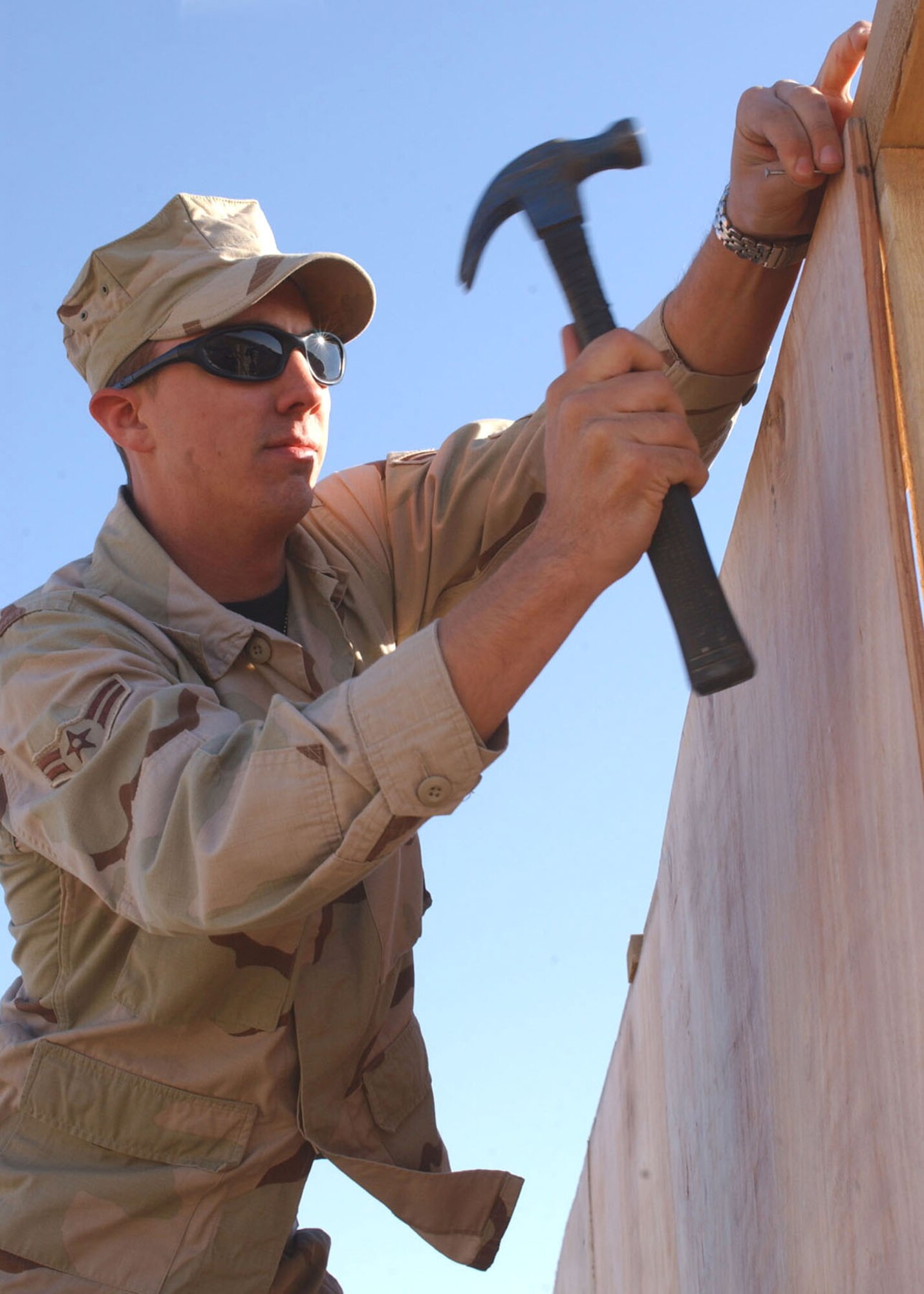 Airman 1st Class Christopher Birkland hammers nails for the exterior wall of an office building being built at Camp Liberty in Iraq Dec. 28. Airman Birkland is a civil engineer with the 1st Special Operations Civil Engineer Squadron at Hurlburt Field, Fla. (U.S. Army photo/Pfc. William Hatton) 
