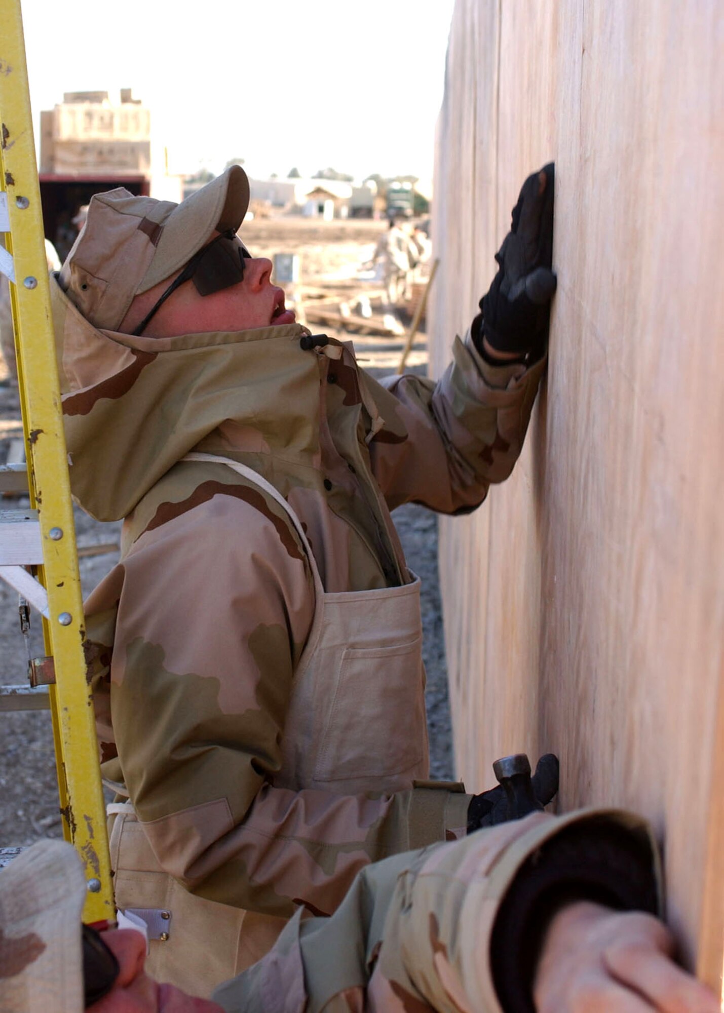 Airman Nick Soracco lifts a panel of wood for the exterior wall of an office building being constructed at Camp Liberty in Iraq Dec. 28. Airman Soracco is a civil engineer with the 1st Special Operations Civil Engineer Squadron at Hurlburt Field, Fla. (U.S. Army photo/Pfc. William Hatton) 

