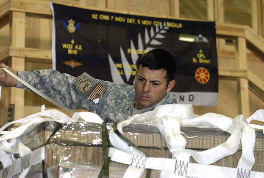 Staff Sgt. Raul Mercado finishes building a holiday bundle for delivery to forward-deployed troops in austere locations in theater. Aproximately 50 bundles were air-dropped by C-130 Hercules aircrews assigned to 774th Expeditionary Airlift Squadron between Dec. 23 and 28. Sergeant Mercado is a rigger NCO assigned to the 10th Joint Logistics Task Force. (U.S. Air Force photo/Capt. Vince King Jr.)