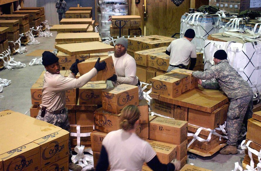 Riggers with the 10th Logistics Task Force work to create holiday bundles for forward troops within the theater Dec. 21. They built more than 50 bundles within a two-day period. The bundles were air-dropped Dec. 23 through 28 to forward-deployed servicemembers by C-130 Hercules deployed to the 774th Expeditionary Airlift Squadron. (U.S. Army photo/Sgt. Michael J. Taylor)        