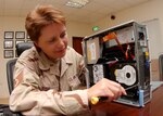 Tech. Sgt. Tia Fish, a client support administrator and NCOIC of the commander support staff, performs maintenance on a computer. Computer system maintenance in deployed locations such as Sergeant Fish's can be challenging due to dusty conditions. Sergeant Fish is deployed from the 19th Air Force Initial Flight Screening office. (Courtesy photo)                          