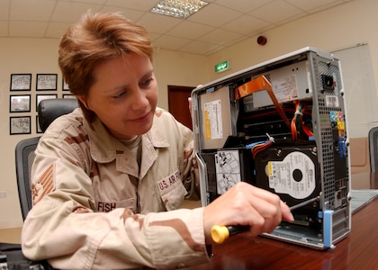 Tech. Sgt. Tia Fish, a client support administrator and NCOIC of the commander support staff, performs maintenance on a computer. Computer system maintenance in deployed locations such as Sergeant Fish's can be challenging due to dusty conditions. Sergeant Fish is deployed from the 19th Air Force Initial Flight Screening office. (Courtesy photo)                          
