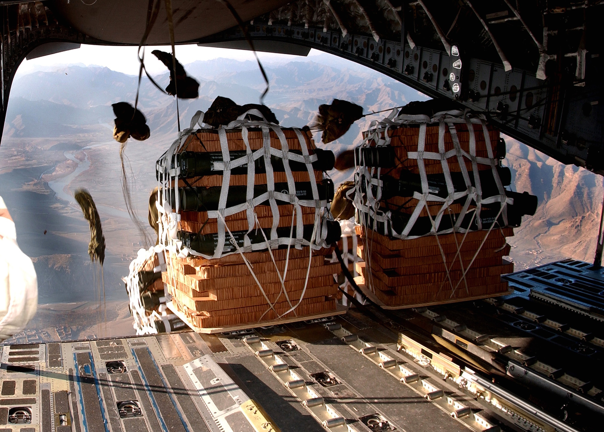 Parachutes begin to open on supply pallets being airdropped from a C-17 Globemaster III to servicemembers Jan. 2 at a remote camp in Afghanistan. The aircraft is from a desert air base in Southwest Asia. (U.S. Air Force photo/Senior Airman Ricky J. Best)