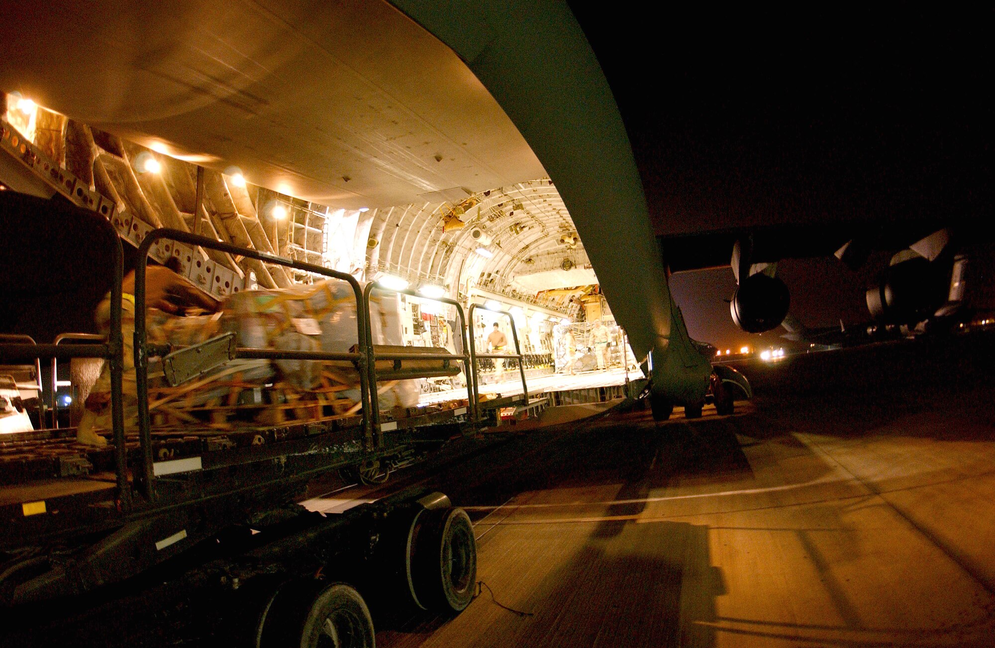Airmen at an air base in Southwest Asia work in the early morning hours of Jan. 2 to load cargo onto a C-17 Globemaster III heading to Bagram Air Base, Afghanistan. Some of the cargo will be airdropped later that day to servicemembers at remote camps in Afghanistan. (U.S. Air Force photo/Senior Airman Ricky J. Best)
