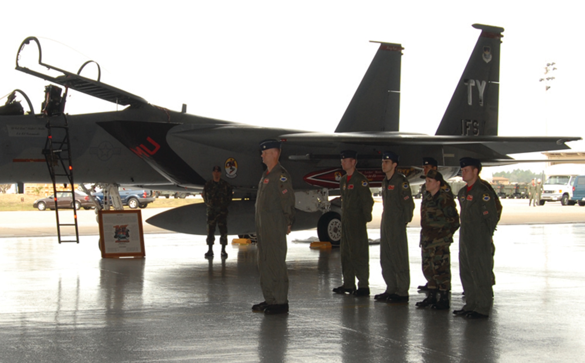 Lt. Col. Malcolm Kemeny (far left), former 1st FS director of operations, stands in formation with fellow members of the 1st FS and 1st AMU during the inactivation ceremony held in Hangar 1 Dec. 15. 