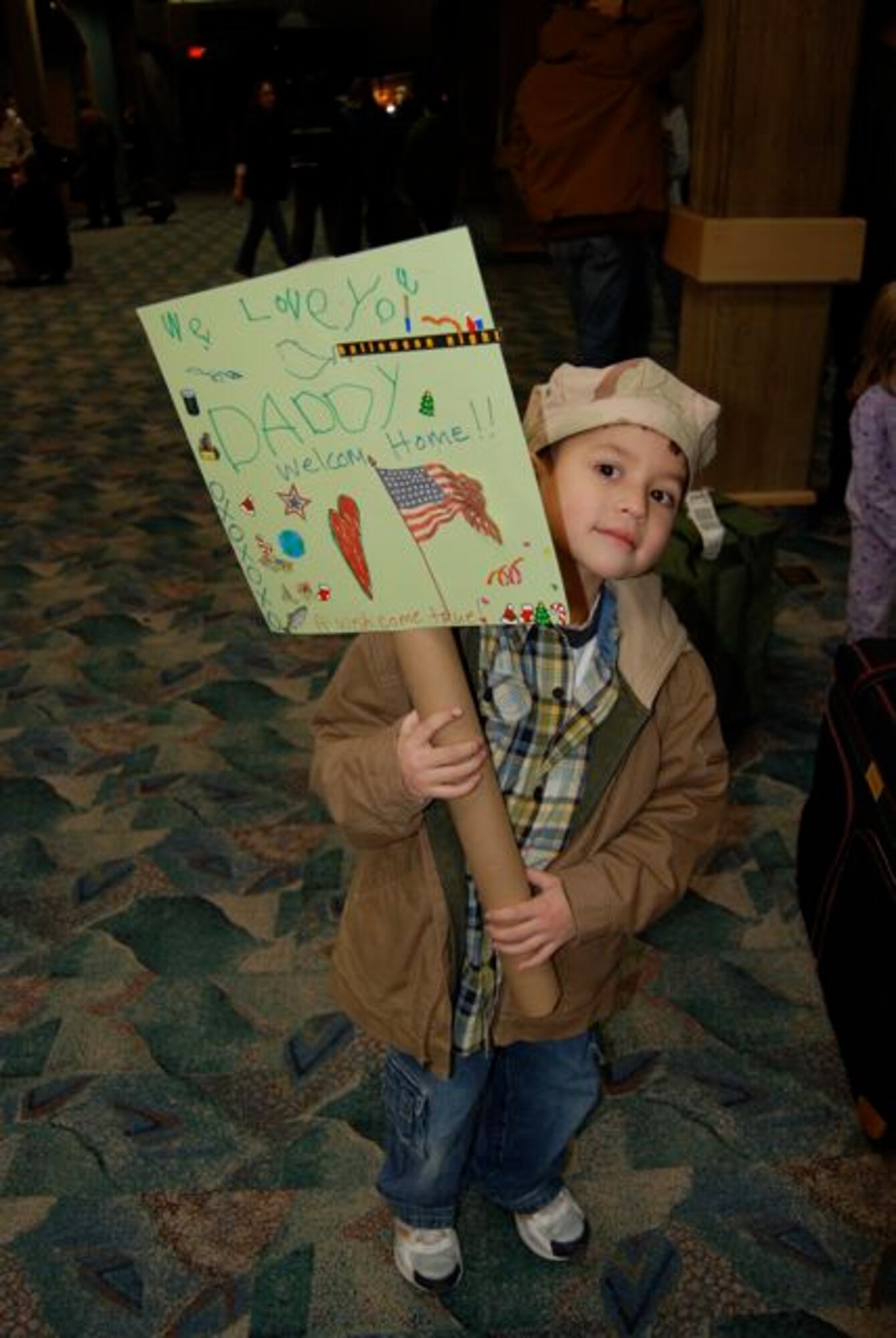 Diego Prim, holds a sign he made for his dad, Staff Sgt. James Prim, 28th Civil Engineer Squadron. Sergeant Prim returned Dec. 22 from a 7-month deployment to Contingency Operating Base Speicher, Iraq. Sergeant Prim was one of 42 28th CES Airmen deployed in support of the continuing global war on terrorism and responsible for maintaining base infrastructure in their overseas location.