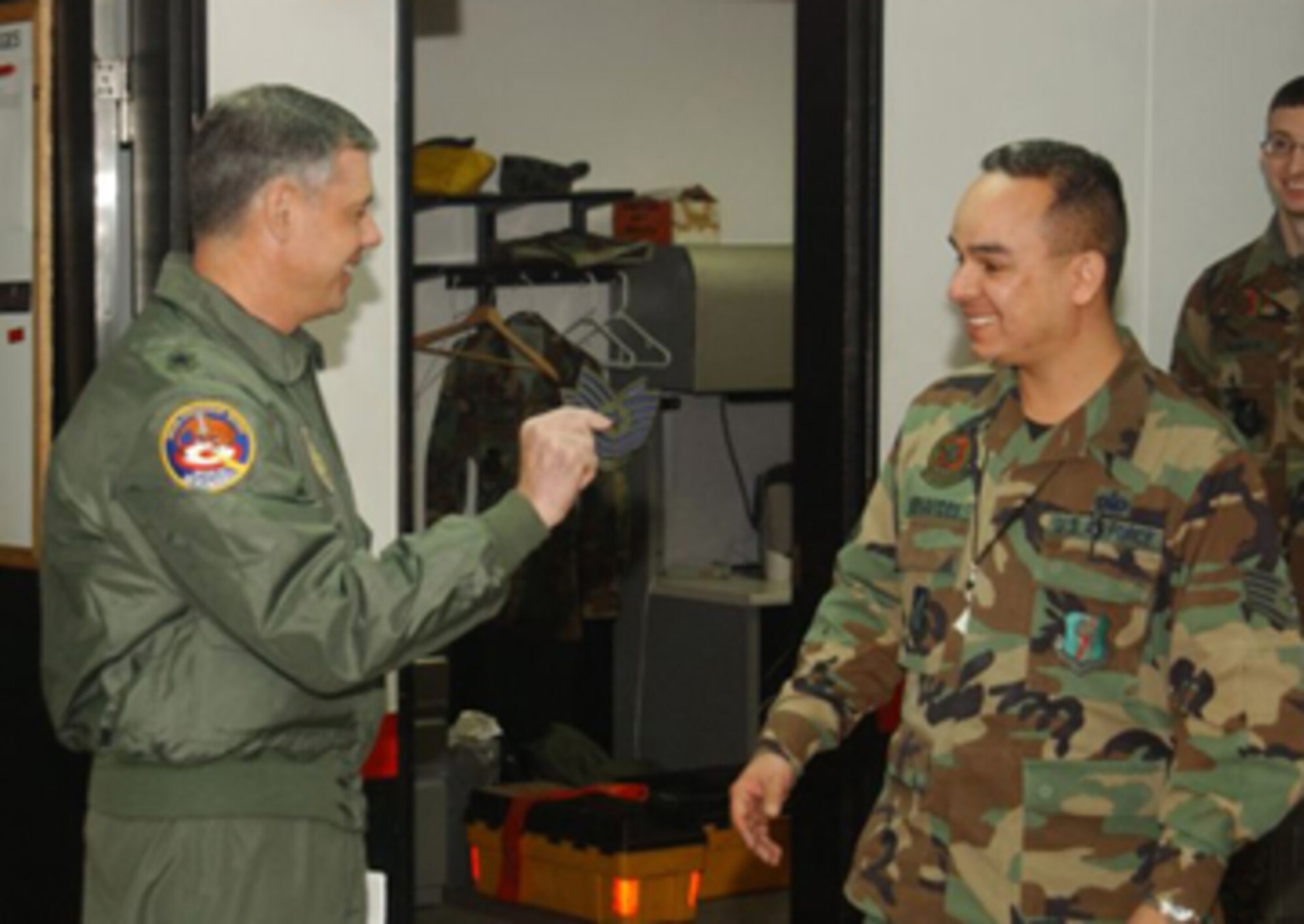 MISAWA AB, JAPAN -- Brig. Gen. Sam Angelella, 35th Fighter Wing and installation commander, surprises Staff Sgt. Jason Benavides, 35th Aircraft Maintenance Squadron, with a STEP promotion here Dec. 22. STEP promotions are a rare reward for hard working members of the enlisted Air Force.