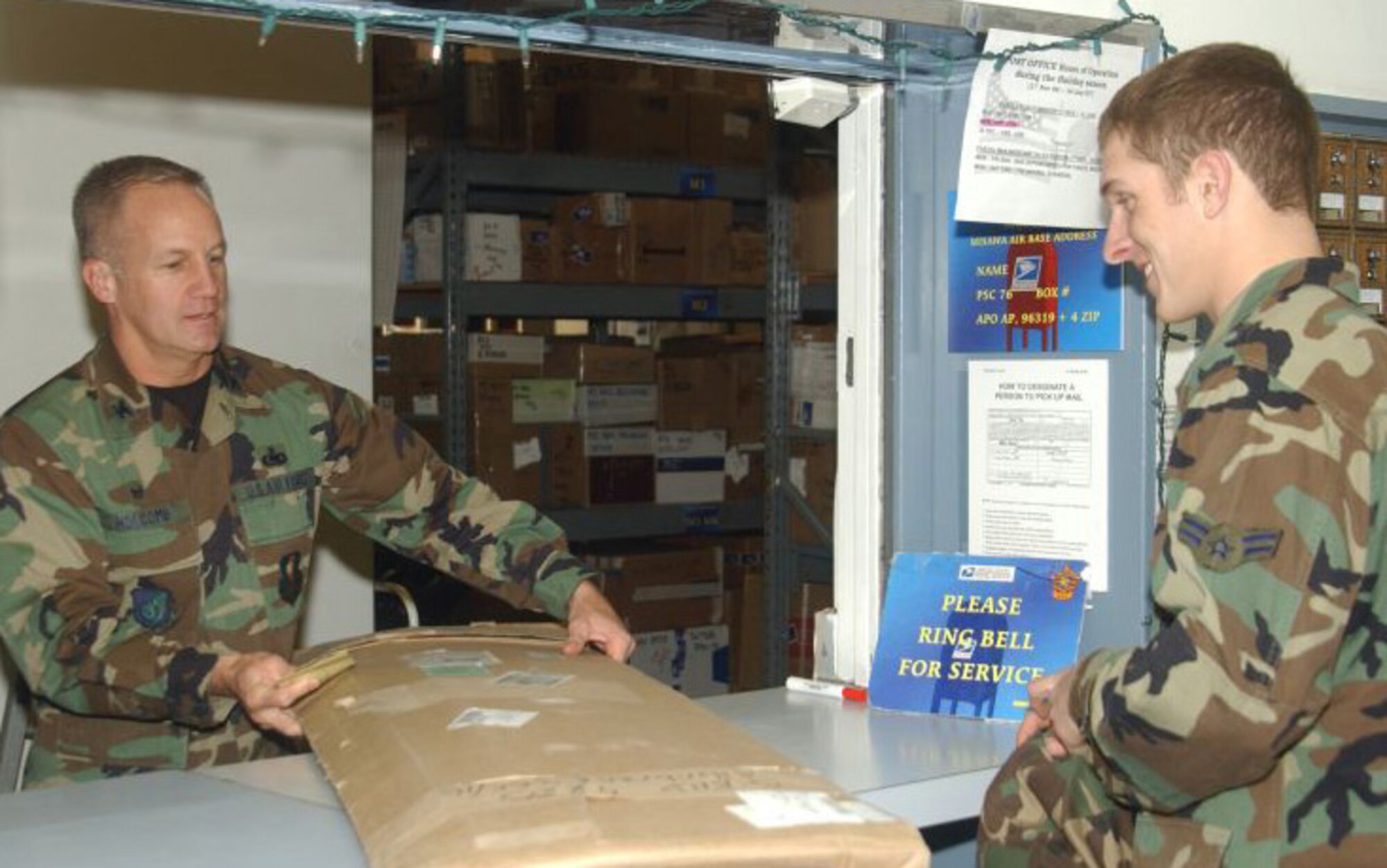 MISAWA AIR BASE, Japan -- Col. Arnie Holcomb, 35th Mission Support Group commander, hands a Misawa post office customer his package. Colonel Holcomb is helping the post office staff during the holiday season. The post office requests volunteers to help during the holiday season when they receive the most incoming and outgoing mail. (USAF photo by Airman Benjamin Wilson)