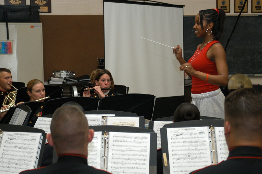 Junior Aqura Lacey conducts the Parris Island Marine Band in the John Philip Sousa march, The Thunderer, May 3 at Dupont Manuel High School's Performing Arts School.  At the end of the piece, Chief Warrant Officer 3 Christian Flores, the Marine band's director, presented Lacey with an engraved conductors's baton.