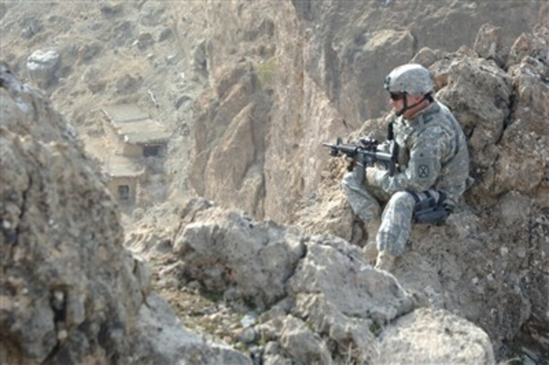 U.S. Army Staff Sgt. Aldridge looks over a cliff as he provides security while his fellow soldiers, Afghan National Army soldiers and U.S. Air Force airmen of the 755th Explosive Ordnance Disposal Unit move to an enemy weapons cache point on the side of a mountain in Mandikowl, Afghanistan, on Dec. 23, 2006.  Aldridge is with the10th Mountain Division's Special Troops Battalion.  