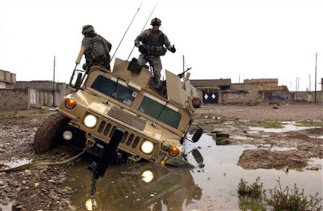 U.S. Army soldiers dismount from their Humvee after getting stuck in a mud hole while patrolling through Kirkuk, Iraq, on Dec. 28, 2006.  The soldiers are from Charlie Company, 2nd Battalion, 35th Infantry Regiment, 25th Infantry Division.  