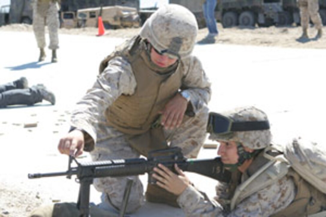 Lance Cpl. Devon Preiser, Jane Wayne Day range coach, gives Alicia Lara a crash course in correct sight alignment of the M-16 rifle at the Combat Center?s Range 500 during the 1st Tank Battalion Jane Wayne Day Oct. 4.