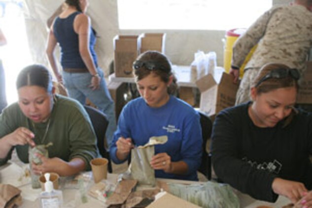 Nathalie Hernandez, Ashton Reagin and Michelle Sanchez enjoy some Meals-Ready-to-Eat at the Combat Center?s Range 500 during the 1st Tank Battalion Jane Wayne Day Oct. 4.