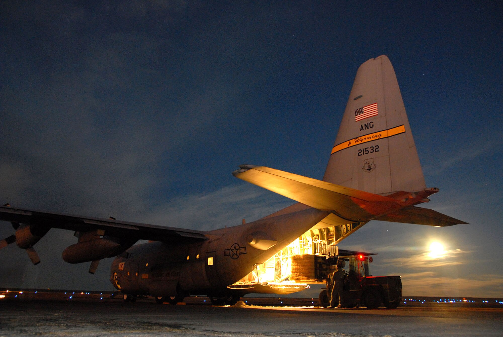 Staff Sgt. Leslie Wuerflein of the 140th Vehicle Maintenance section loads two one-ton hay bales Jan. 3 onto a C-130 Hercules out of Cheyenne, Wyo. She is readying the aircraft in Pueblo, Colo., for an early-morning emergency feeding mission the next day. (U.S. Air Force photo/Senior Master Sgt. John Rohrer)