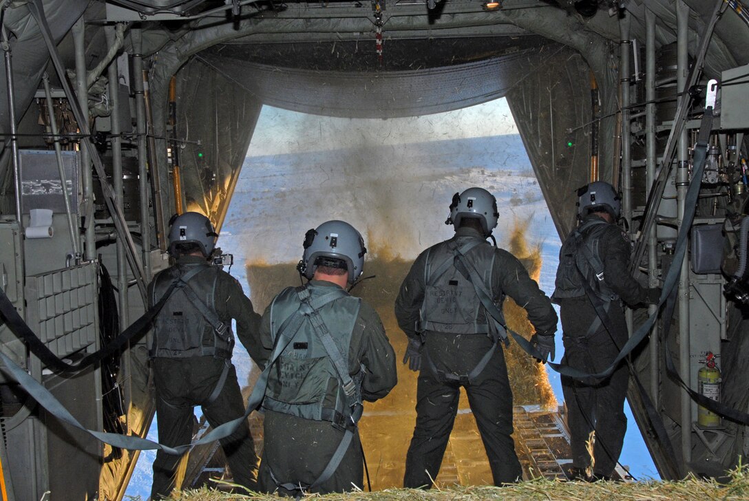 Members of the Wyoming Air National Guard drop one-ton bales of hay from a C-130 Hercules over southeast Colorado to help stranded livestock Jan. 3. The two-day mission has brought support from Colorado and Wyoming to help livestock stranded by a snowstorm that left 5-foot drifts of snow. The 60,000 stranded cattle need food to survive until ranchers can reach them. (U.S. Air Force photo/Senior Master Sgt. John Rohrer)