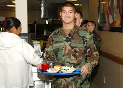 Airman Jay Powelson, 342nd Training Squadron, pays for his meal and makes his way toward one of the three dining areas during the grand opening of the new dining facility Jan. 3.  The dining facility, located on the Lackland Training Annex at Lackland Air Force Base, Texas, mainly serves technical students and instructors from the 342nd, 343rd and 344th TRS, and members of the 90th Intelligence Squadron. The facility can hold up to 1,500 diners, has four serving lines, modern lighting and wooden floors. Construction of the dining facility, which replaced the 35-year-old Medina Inn, is among $60.3 million in major building projects scheduled for opening early this year. (USAF photo by Alan Boedeker)                           