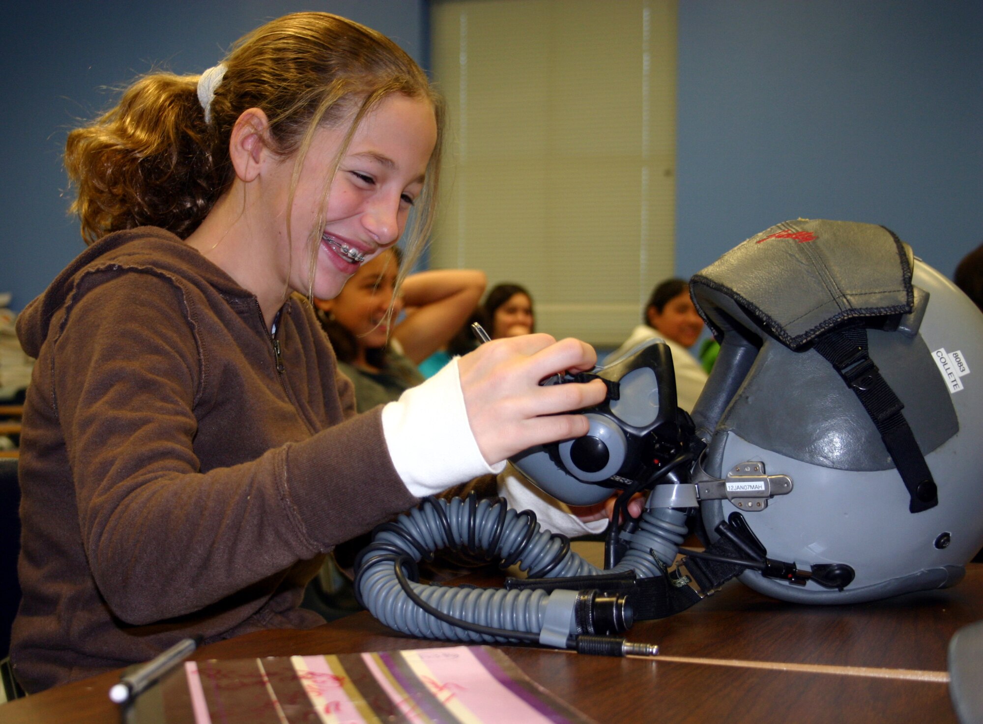 A sixth-grade student from San Felipe Memorial Middle School takes a closer look at Capt. Daniel Collette’s flight helmet during Career Day.  Capt. Collette, 87th Flying Training Squadron, was one of many volunteers from Laughlin to take part in the annual event. (U.S. Air Force photo by 2nd Courtney Kippenberger)   