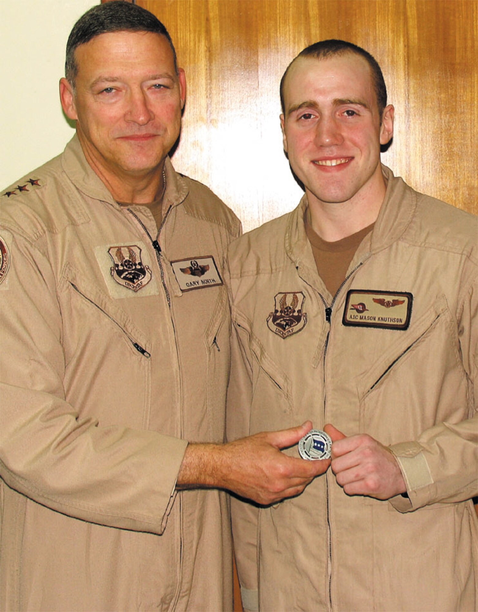 Lt. Gen. Gary North, 9th Air Force Commander, presents Airman 1st Class Mason Knuthson, 2nd Airlift Squadron, with a coin at a deployed location in Southwest Asia.