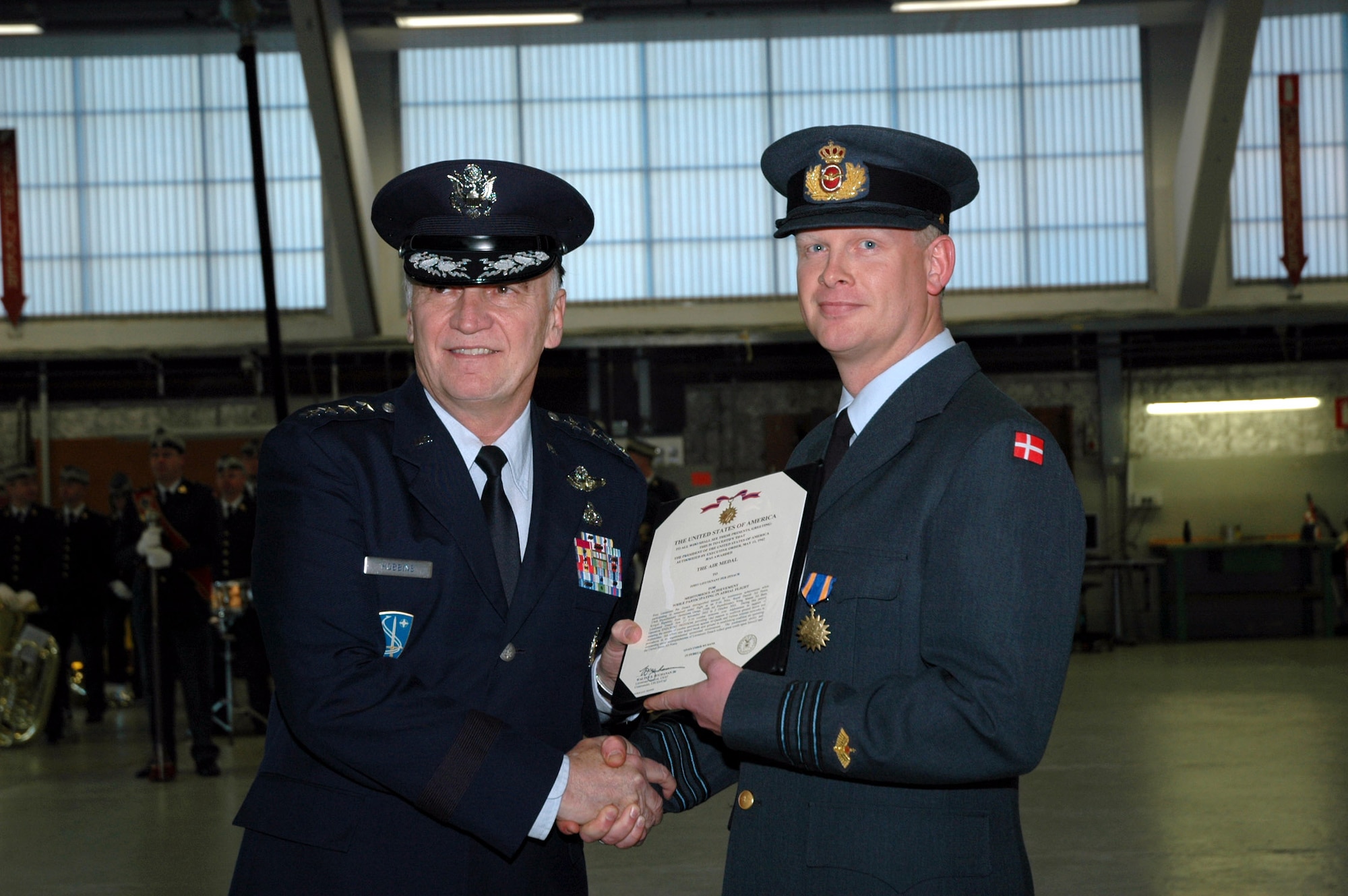 Gen. William T. Hobbins (left) presents a U.S. Air Medal  to Capt. Per Zesach Jan. 2 at Fighter Wing Skrydstrup, Denmark. The general presented 35 Air Medals to Danish fighter pilots recognizing their achievement while operating under the 376th Air Expeditionary Operations Group at Manas Air Base, Kyrgyzstan. General Hobbins is the U.S. Air Forces in Europe commander. Captain Zesach is a Danish F-16 pilot who flew 27 combat missions in support of Operation Enduring Freedom from October 2002 to October 2003. (U.S. Air Force photo/Maj. Krista Carlos) 
