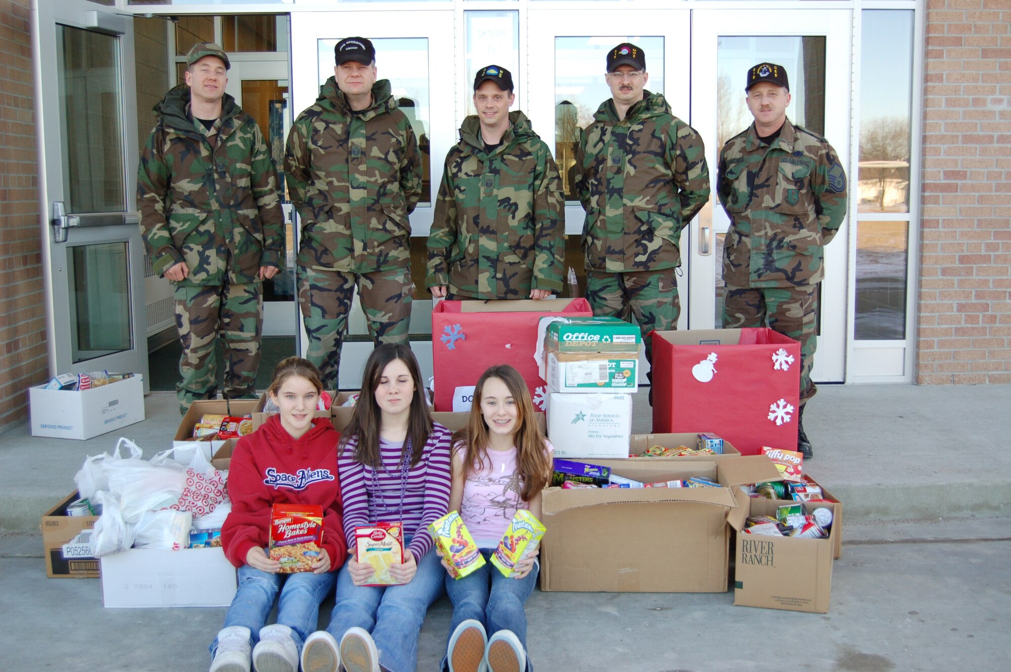 Base first sergeants received more than 900 food items for the food pantry from Twining Middle School and Twining Elementary School students Dec. 21. The students and facility posted fliers and collected food items for five days and the highest earners were congratulated by the first sergeants with a pizza party. (photo/Airman 1st Class Ashley Coomes)