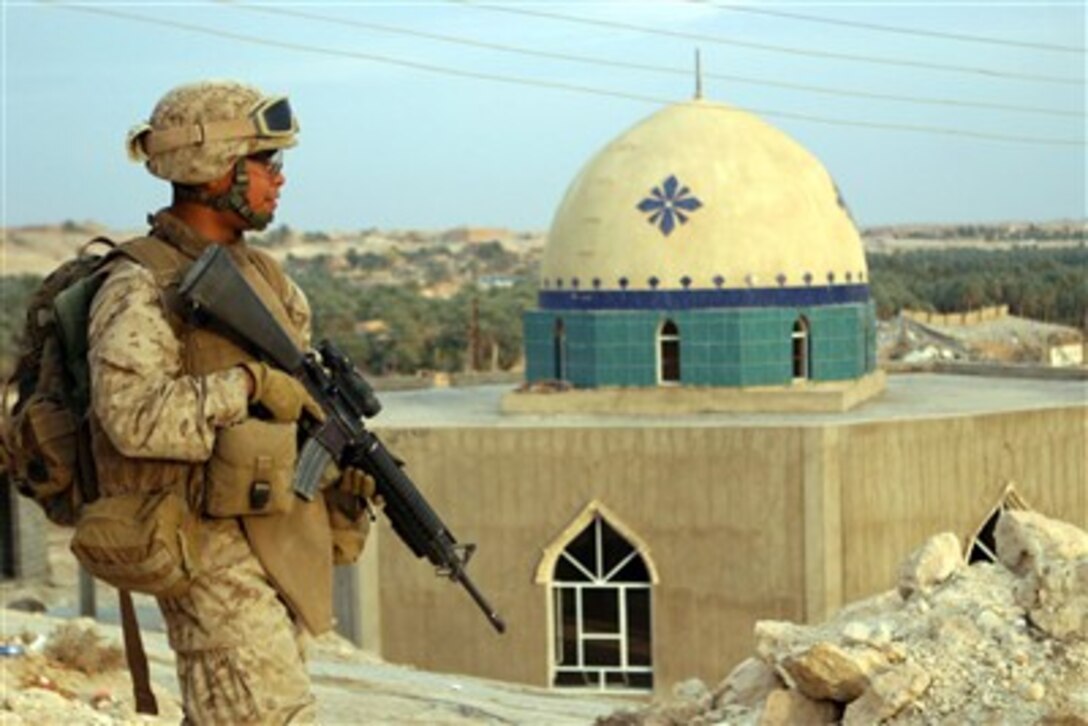 U.S. Navy Hospital Corpsman Joseph V. Poquiz keeps an eye on the street as he conducts a patrol in Haqlaniyah, Iraq, on Dec. 22, 2006. Poquiz is attached to the 2nd Battalion, 3rd Marine Regiment, Regimental Combat Team 7, I Marine Expeditionary Force (Forward).  