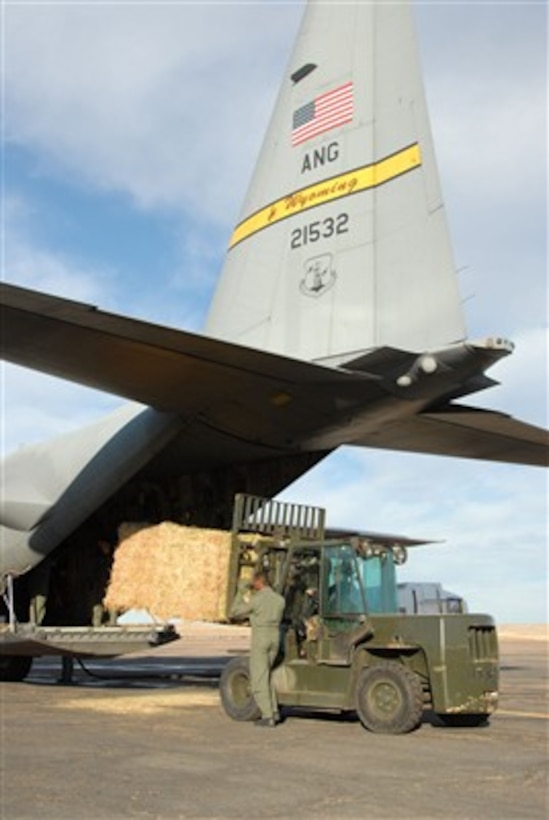 U.S. Air Force Staff Sgt. Leslie Wuerflein loads two one-ton hay bales into a Wyoming Air National Guard C-130 Hercules aircraft at the Pueblo Memorial Airport in Pueblo, Colo., on Jan. 3, 2007.  The hay will be dropped near La Junta, Colo., to help feed livestock that have been stranded from a snowstorm that has impacted the area. Wuerflein is attached to the 140th Vehicle Maintenance, Colorado Air National Guard.  