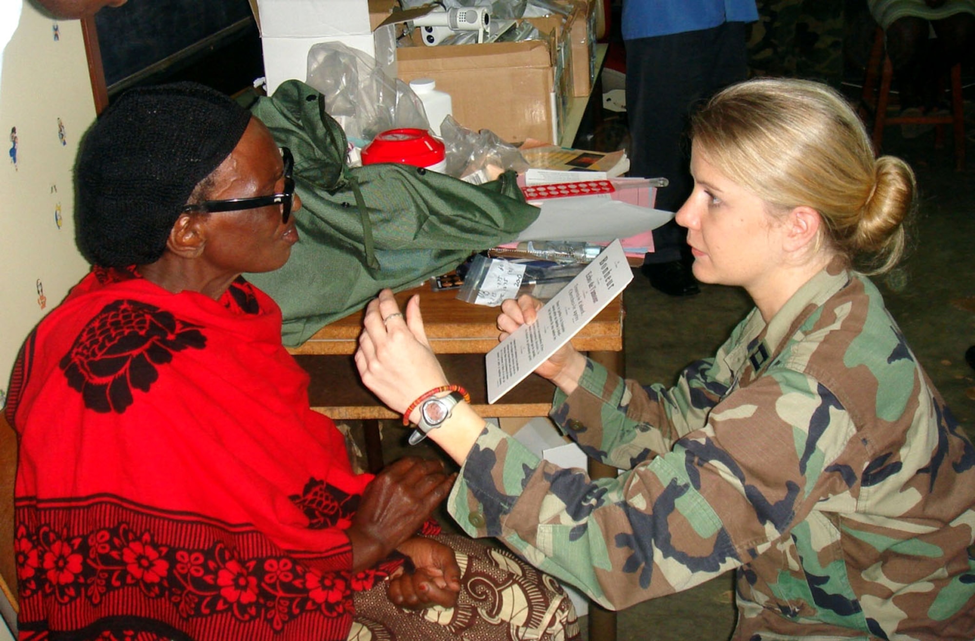 Capt. Christie Barton examines a Rwandan woman during a medical capabilities mission that five medics from around the U.S. European Command participated in recently. The group from Aviano Air Base, Italy, and Ramstein AB, Germany, performed eye and dental exams for nearly 1,500 people, and in conjunction with the Rwandan Military Defense Force and the International Red Cross, they held medical seminars for 50 local doctors as part of the two-week military-to-military operation. Captain Barton is an optometrist from the 435th Medical Group at Ramstein AB. (U.S. Air Force photo/Staff Sgt. Chad Padgett) 

