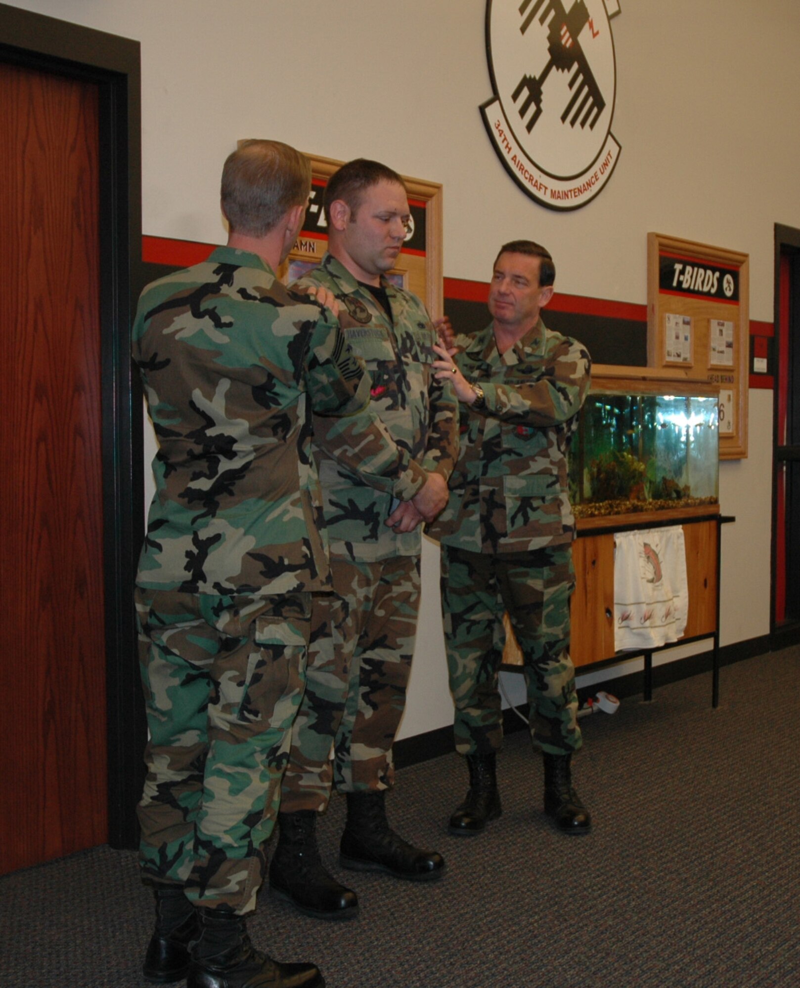 Col. Jeffry Smith, 28th Bomb Wing commander, and Command Chief Master Sgt. John Gillette, 28th Bomb wing command chief, congratulate Tech Sgt. Ross Haverstock, 28th Aircraft Maintenance dedicated crew chief, on his step promotion Dec. 22.