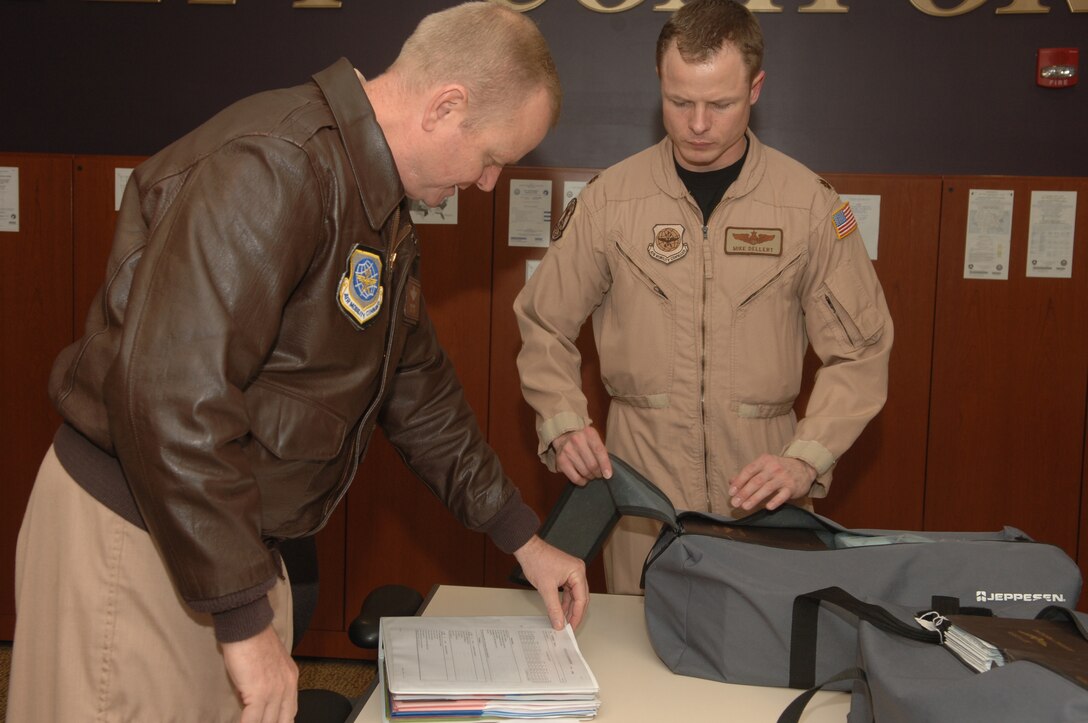 ANDREWS AFB, Md. -- Lt. Col. Chris J. Kampsen and Maj. Michael T. Dellert, 99th Airlift Squadron C-20 pilots, discuss and pack flight materials needed for their mission prior to departing on their deployment.