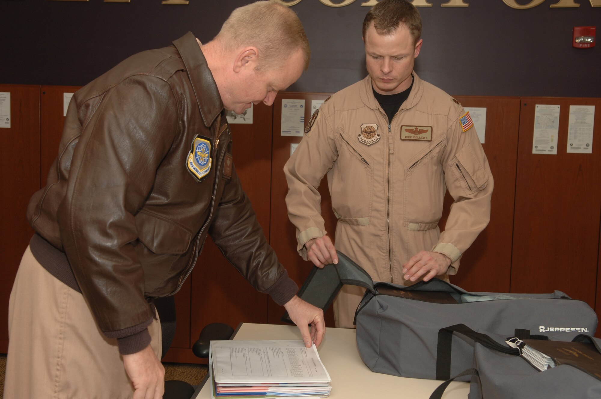 ANDREWS AFB, Md. -- Lt. Col. Chris J. Kampsen and Maj. Michael T. Dellert, 99th Airlift Squadron C-20 pilots, discuss and pack flight materials needed for their mission prior to departing on their deployment.