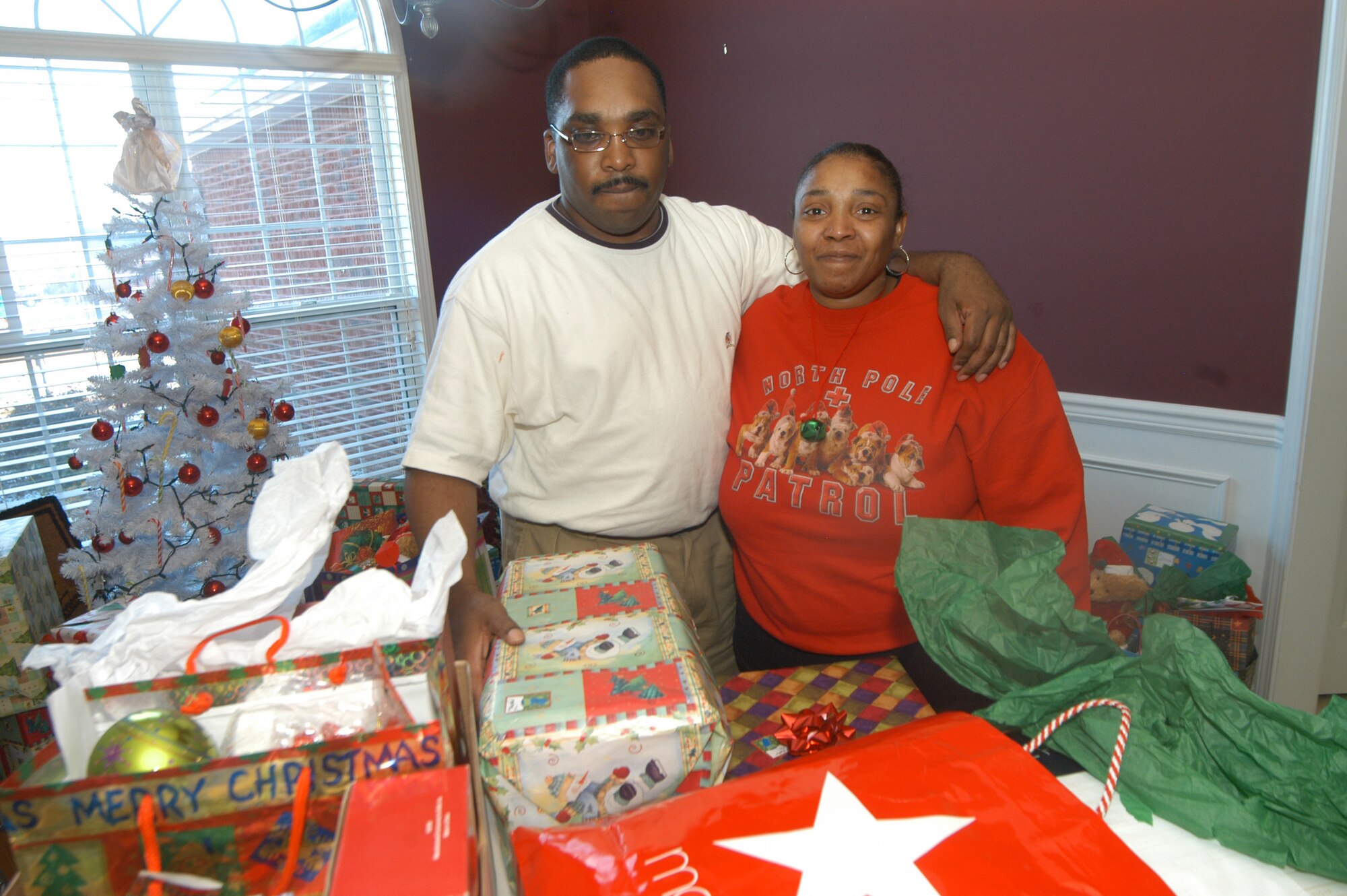 Shawn and Lisa Williams are surrounded by gifts from members of the 742nd Combat Sustainment Group. The group  adopted the family for Christmas after they lost their home to fire. U.S. Air Force photo by SUE SAPP